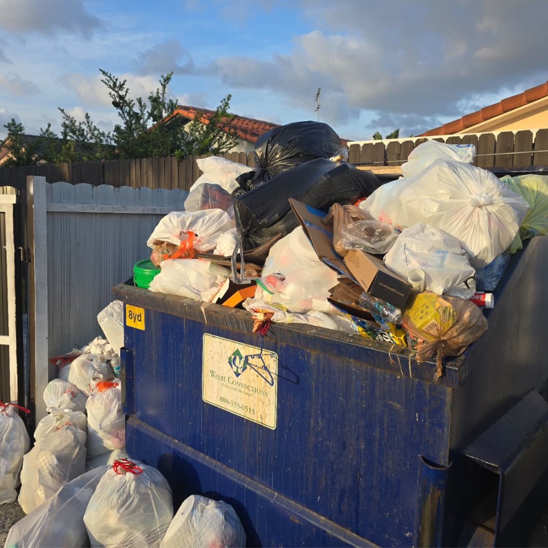Junk and household waste in a dumpster awaiting removal.