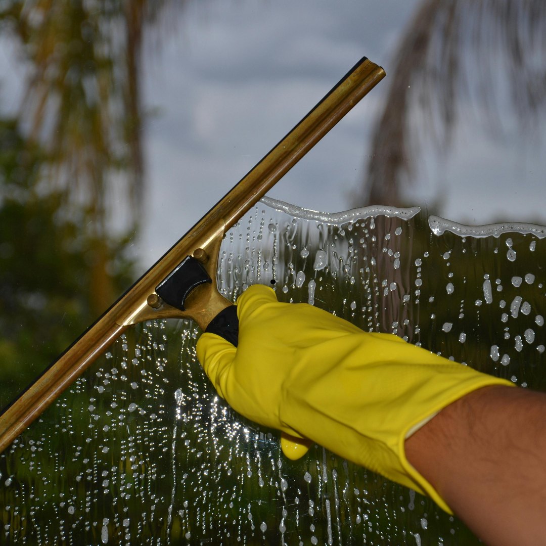Window cleaning with a squeegee on wet glass.